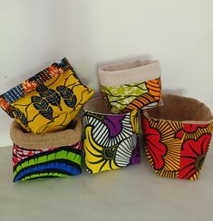 four baskets are stacked on top of each other with different designs and colors in them