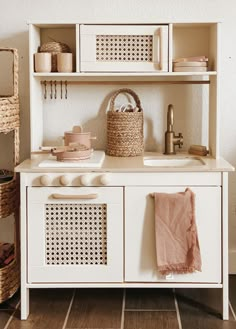 a white cabinet with baskets and dishes on it