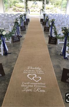 an aisle decorated with white flowers and blue ribbons