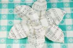 a flower made out of sheet music notes on a blue and white checkered tablecloth