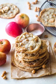 an apple pie is stacked on top of each other next to some nuts and apples