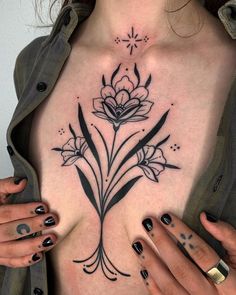 a woman's chest with flowers on it and her hands holding the top part