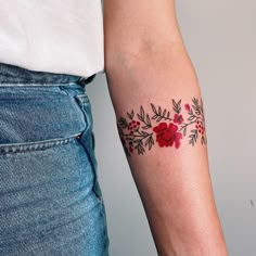 two people with tattoos on their arms and one has a red flower tattoo on the arm