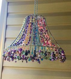 a chandelier hanging from the side of a house with beads all over it