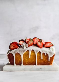 a cake with white icing and strawberries on top