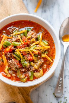 a white bowl filled with chili and meat soup