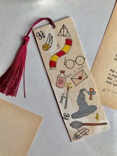 a bookmark with harry potter stickers on it next to an envelope and some other items