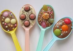 five spoons with different types of candies in them