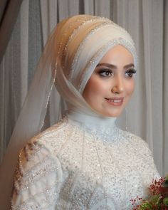 a woman wearing a veil and holding a bouquet