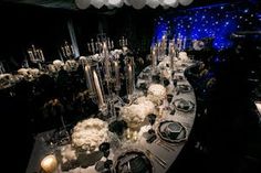 a long table is set up with white flowers and candles for an elegant wedding reception