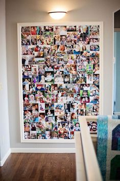 a wall with many pictures on it in a room next to a bed and stairs