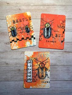 three coasters with bugs on them sitting on a wooden table next to each other