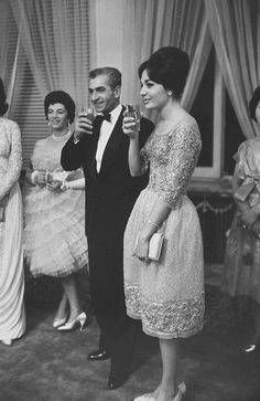 black and white photograph of people in formal wear drinking wine together, with one woman standing next to the man