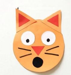 an orange paper cat with eyes and nose