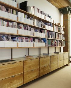 a large book shelf filled with lots of books next to a wall full of shelves