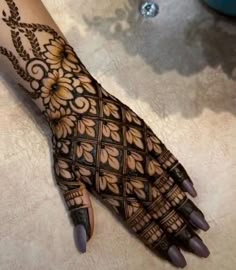 a woman's hand is decorated with hennap and intricate designs on it