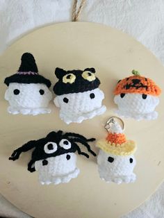 four crocheted halloween ornaments on a white plate with a black and orange hat