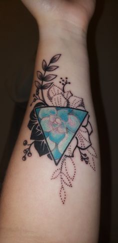 a woman's arm with a tattoo on it and a triangle in the middle