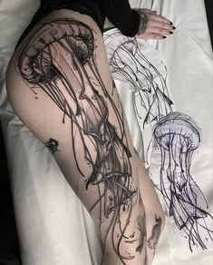 a woman laying on top of a bed next to a jellyfish tattoo design in black ink