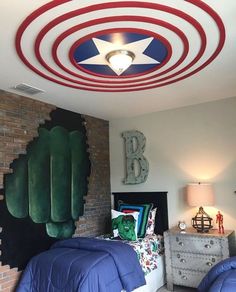 two beds in a room with red, white and blue decor on the ceiling above them