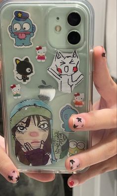 someone holding up their cell phone case with stickers on it and an image of anime characters