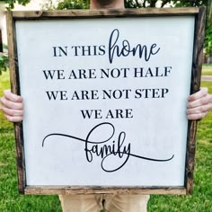 a man holding up a sign that says in this home we are not half we are not step we are family