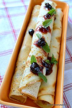 there is a plate with some food on it that looks like crepes and olives