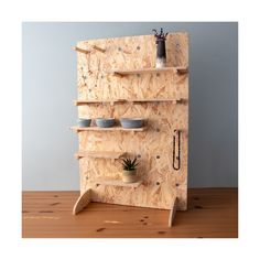 a wooden shelf with pots and spoons on it, made out of plywood