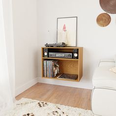 an entertainment center in the corner of a living room with white walls and wood flooring