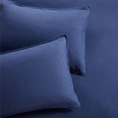 blue sheets and pillows on a bed