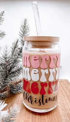 a glass jar filled with liquid sitting on top of a wooden table next to a pine tree