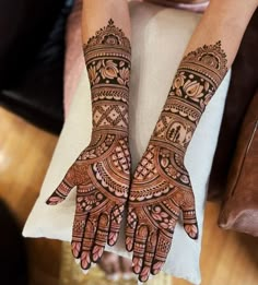 two hands with henna tattoos on them