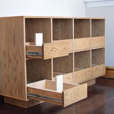 a wooden bookcase with drawers on top of it