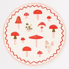 a plate with red mushrooms on it sitting on top of a white tablecloth next to a knife and fork