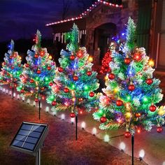 solar powered christmas tree lights in front of a house with holiday decorations on the trees