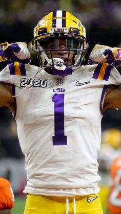 a close up of a football player holding his arms in the air with one hand