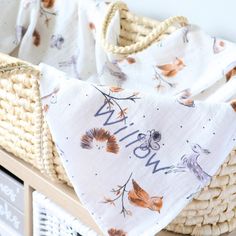 a wicker basket with a white and orange blanket on it that says willow in the center