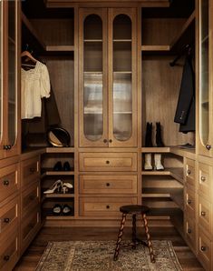 a walk in closet filled with lots of wooden furniture and shoes on top of it