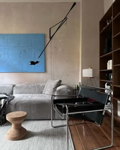 a living room filled with furniture and a painting on the wall