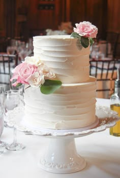 a white wedding cake with pink flowers on top