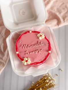 a pink cake in a plastic container with the word mammala written on it