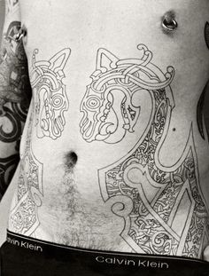 a man with tattoos on his stomach and chest is shown in this black and white photo