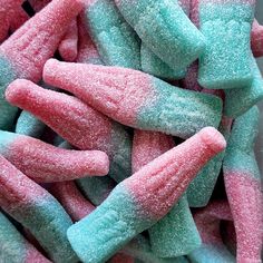 a pile of pink and blue candy canes on top of each other in a bowl