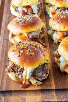 several hamburger sliders on a wooden cutting board