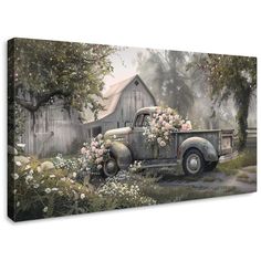 an old truck with flowers on the bed is parked in front of a barn