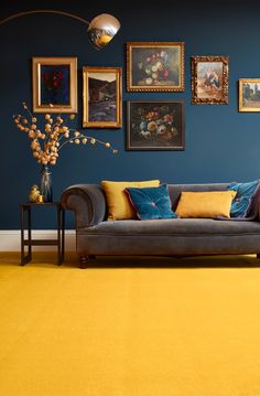 a living room filled with furniture and pictures on the wall above it's yellow carpet