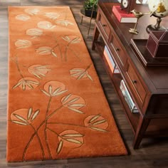 a brown rug with flowers on it in the middle of a wooden flooring area