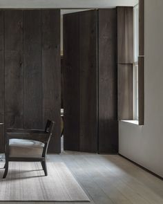 a chair and table in a room with wood paneling