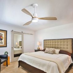 a bed room with a neatly made bed and a ceiling fan