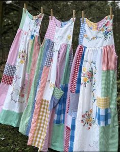 three dresses hanging on clothesline with trees in the background